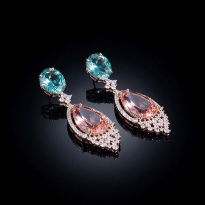 Elegant drop earrings featuring a teardrop-shaped peach-colored stone suspended from an oval turquoise-hued stone, accented with small clear crystals on a dark background.