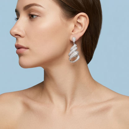 Profile view of a model showcasing silver spiral earrings with intricate stone detailing, styled with elegant, minimalist aesthetics on a flat, solid light blue background for a premium jewelry brand catalog.