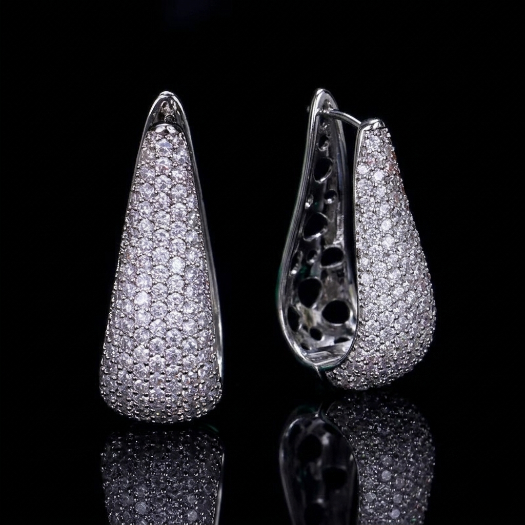 Elegant drop-style hoop earrings featuring white zirconia pavé setting against a dramatic black background.