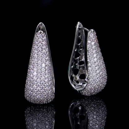 Elegant drop-style hoop earrings featuring white zirconia pavé setting against a dramatic black background.