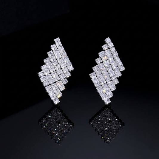 Architectural geometric earrings with clear stone accents, displayed on a black reflective surface for a minimalist luxury aesthetic.