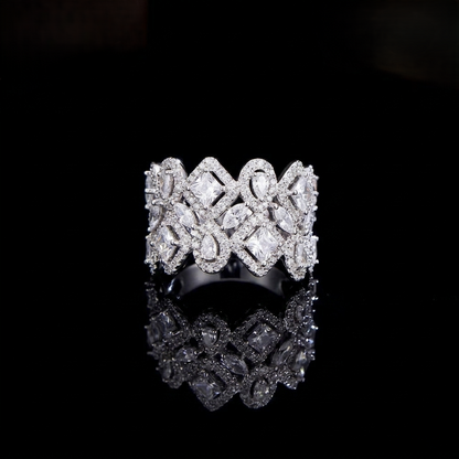 A wide, intricately designed statement ring in a sleek silver-colored finish, featuring a geometric lattice pattern filled with sparkling, clear marquise and square-cut zirconias.
