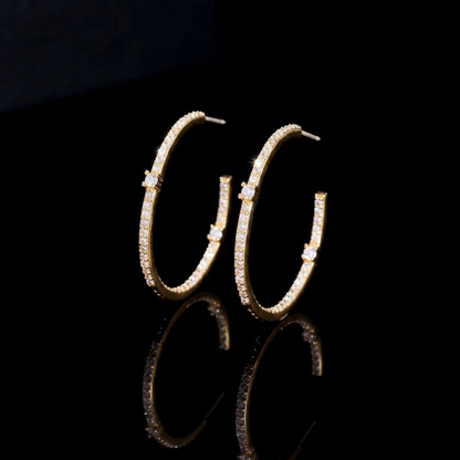 Elegant hoop earrings in a sleek gold-colored finish, fully embellished with a continuous line of sparkling, clear round-cut zirconias.