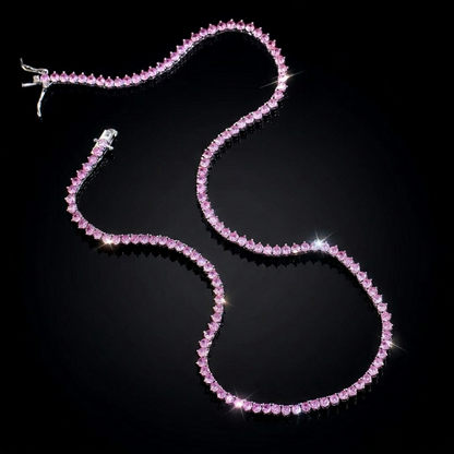 Exquisite pink stone tennis necklace featuring brilliant-cut gems set in a delicate chain, displayed on a sleek, pitch-black reflective surface for a high-end luxury jewelry presentation.