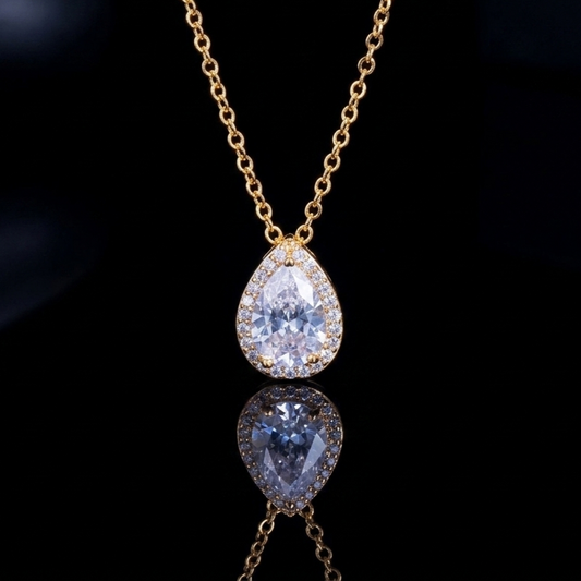 A delicate pear-shaped crystal pendant on a thin, luminous chain against a dark background, representing minimalist and sophisticated luxury style.