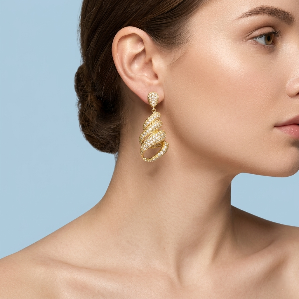 Close-up of a female model wearing gold spiral earrings with white stones, featuring bare shoulders and exposed collarbones, set against a solid, uniform light blue background in a professional jewelry campaign style.